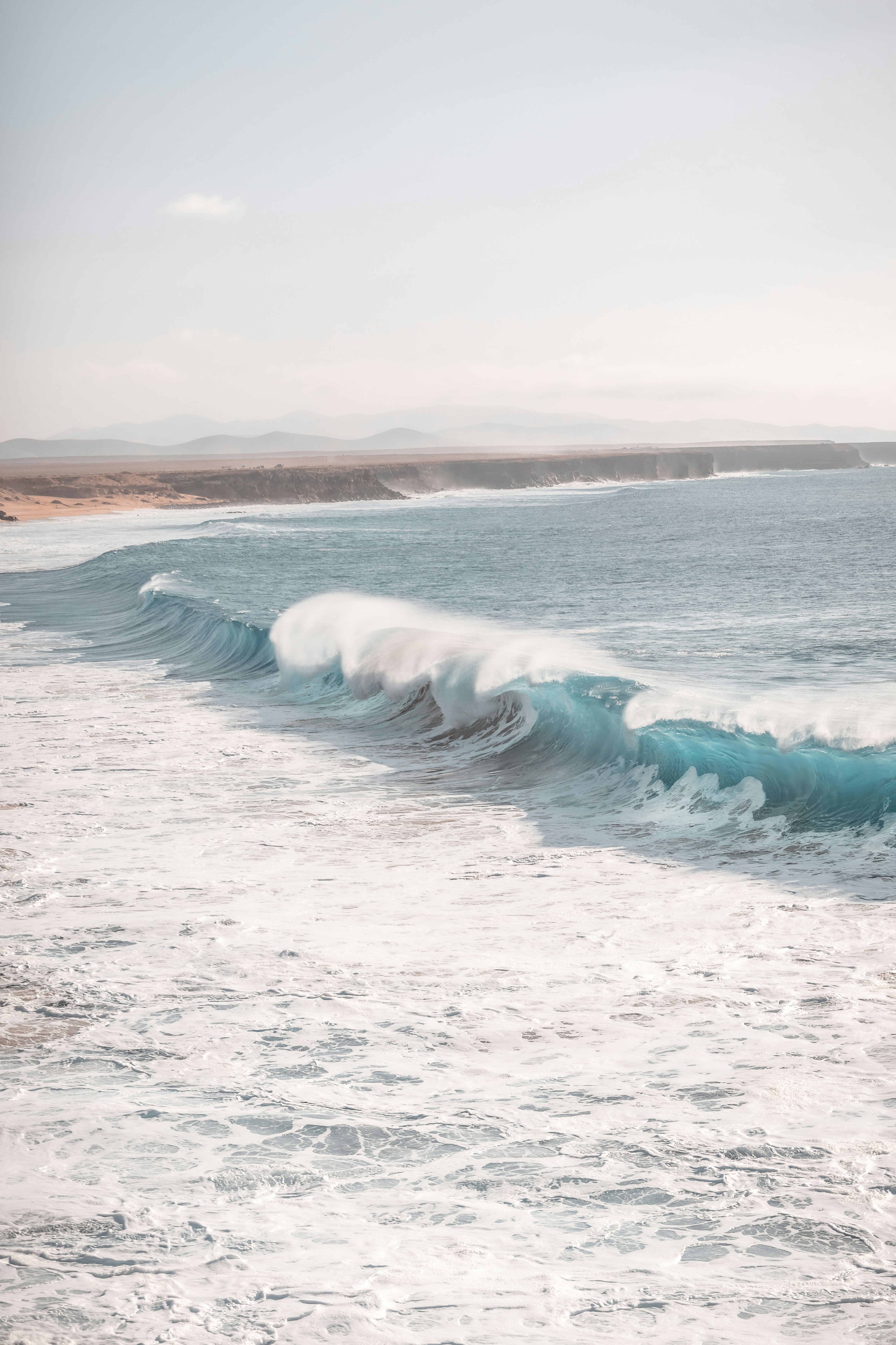 ocean waves crashing on shore during daytime